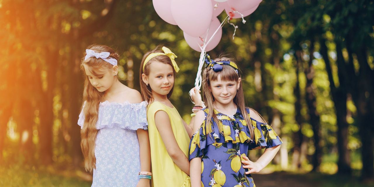 Three girls posing while one holds balloons | Source: Magnific
