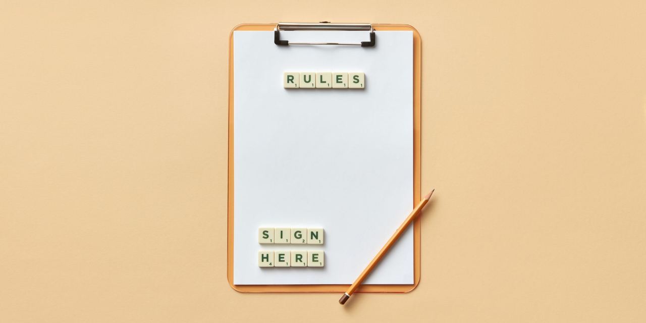 A clipboard with pencil, paper, and tiles spelling 'rules' and 'sign here' | Source: Pexels