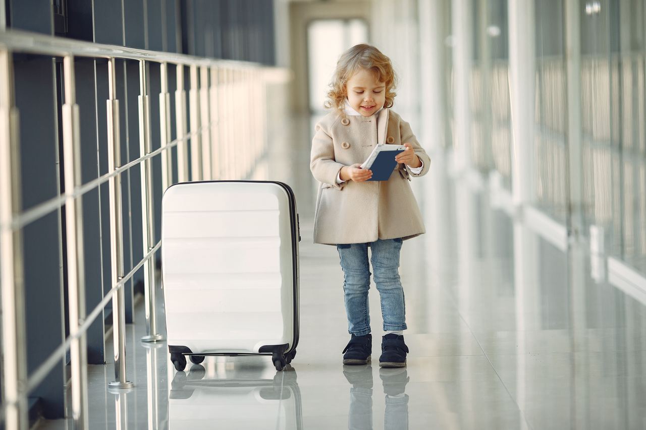 A happy young girl with a suitcase | Source: Pexels