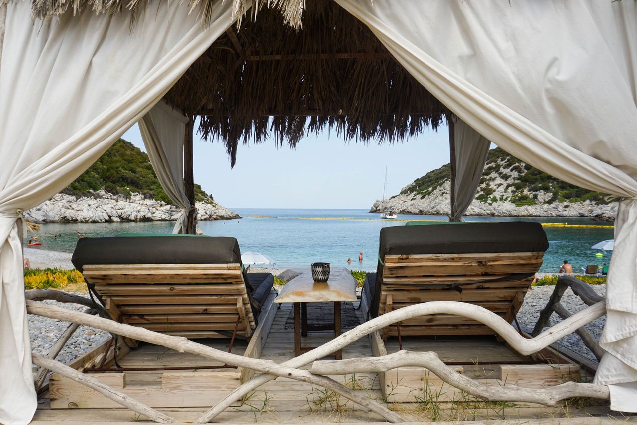 Two pool chairs under a cabana | Source: Pexels