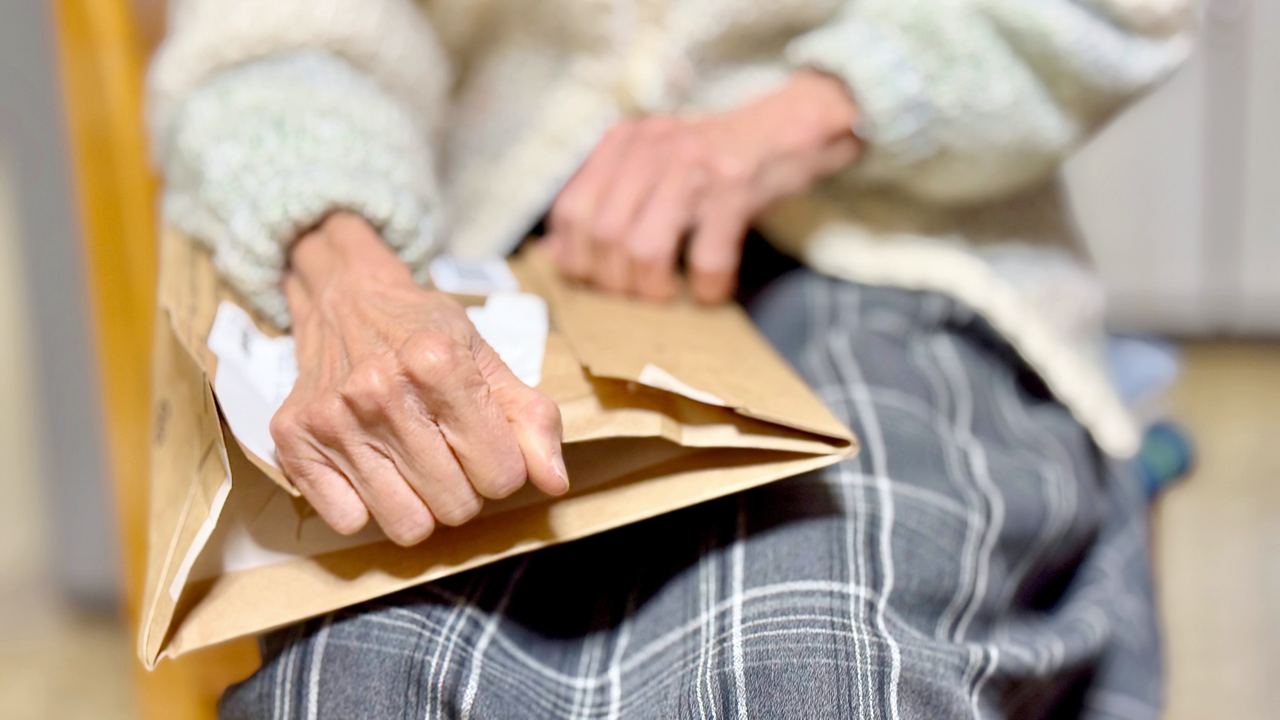 Hands of a person opening a parcel envelope | Source: Shutterstock