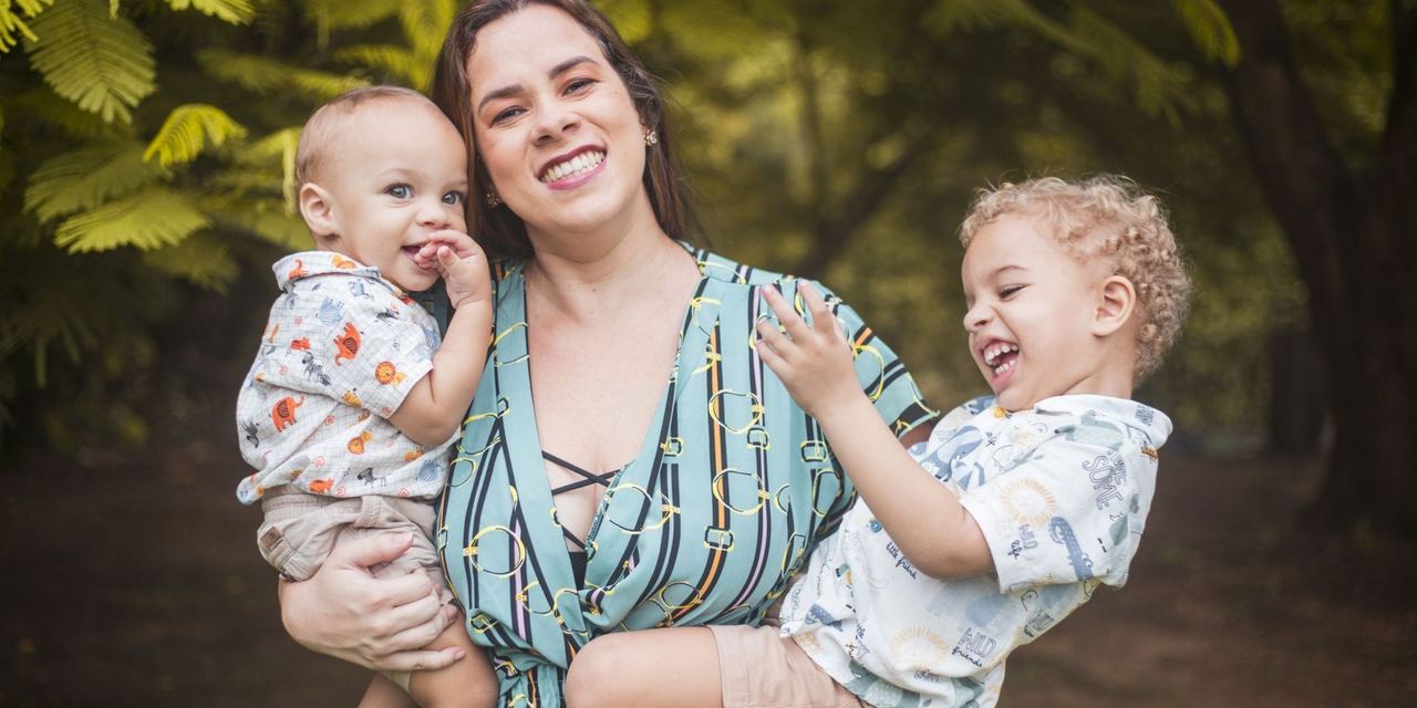 A woman holding two children | Source: Pexels