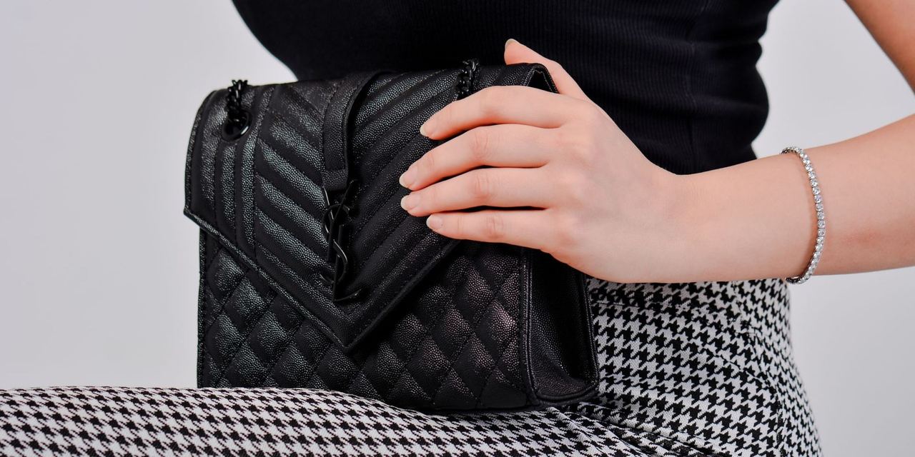 A woman holding a black handbag | Source: Pexels