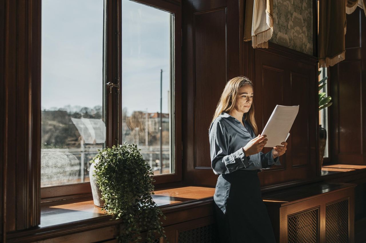 A woman reading report in a office | Source: Getty Images