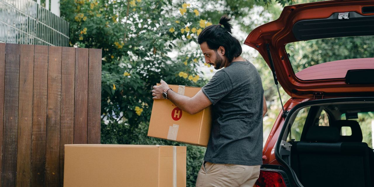 A man offloading boxes from a vehicle | Source: Pexels