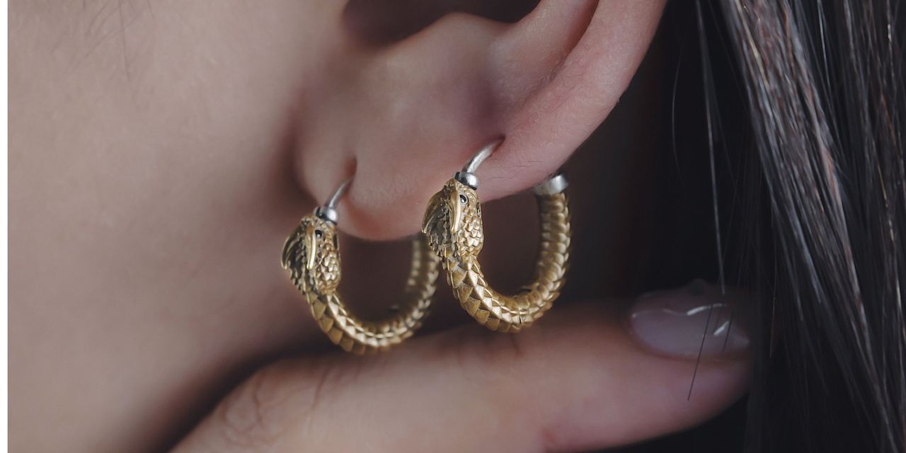 A close-up of gold hoop earrings on a woman's ear | Source: Pexels