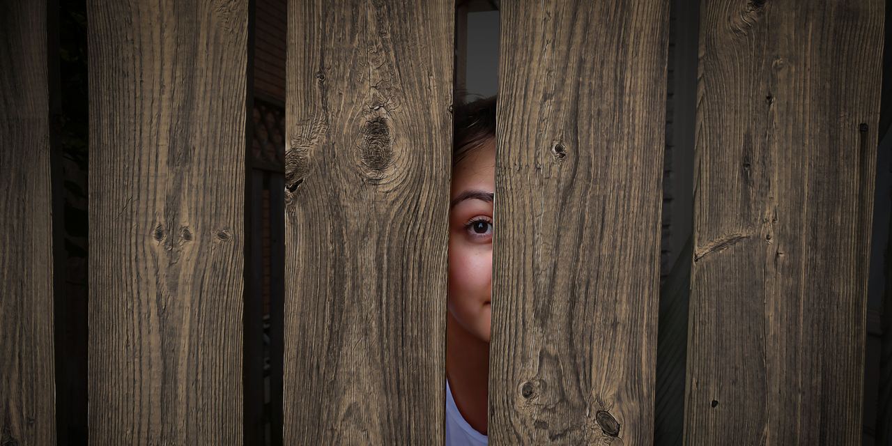 A woman looking through a gap in the fence | Source: Pexels