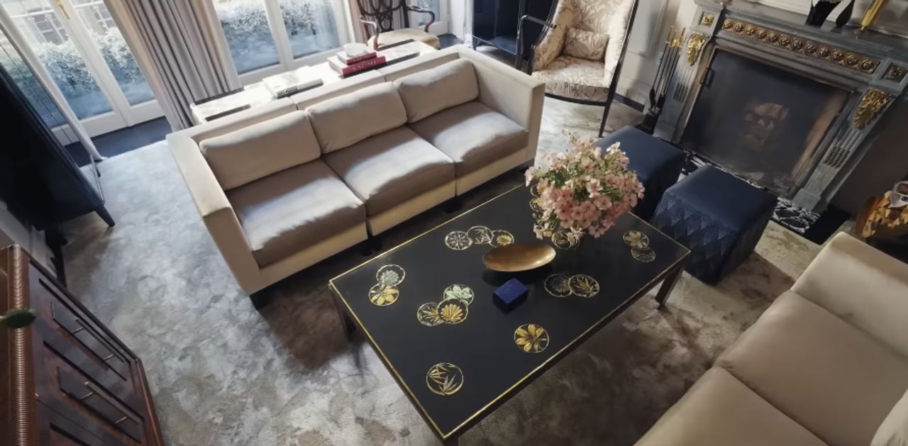 The living room is one of the clearest examples of the home's balance between old-world polish and family comfort. It feels formal enough for a magazine spread, but still soft enough to gather in. | Source: YouTube/Architectural Digest