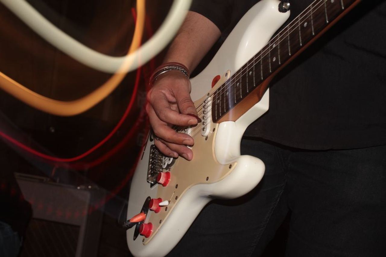 Musician skillfully plays an electric guitar on stage, capturing musical intensity.