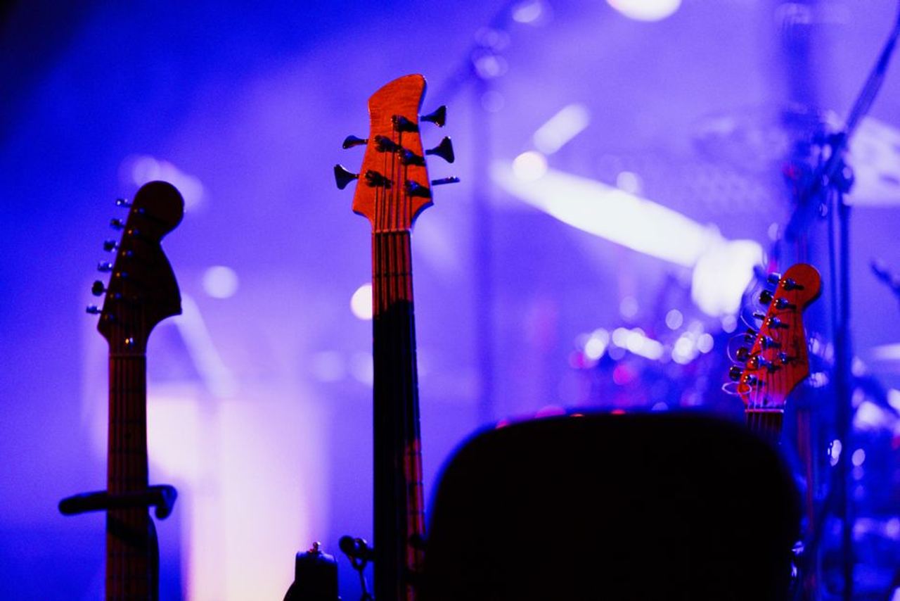 Electric guitars on stage under colorful concert lights, capturing the vibrant music atmosphere.