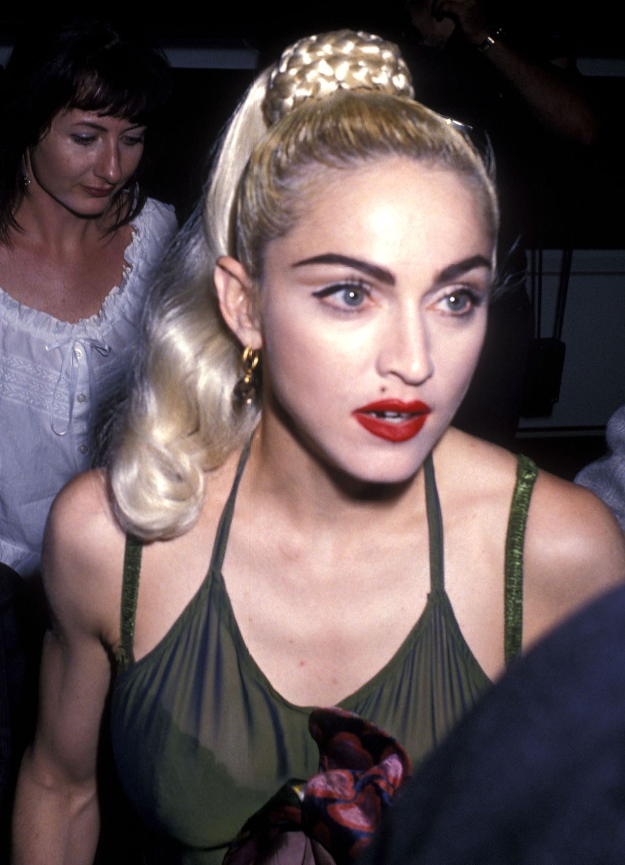 By 1990, Madonna was photographed with a high blond ponytail, sharply defined eye makeup, and bright red lipstick. The close-up reflects another distinct look in her evolving public image. | Source: Getty Images