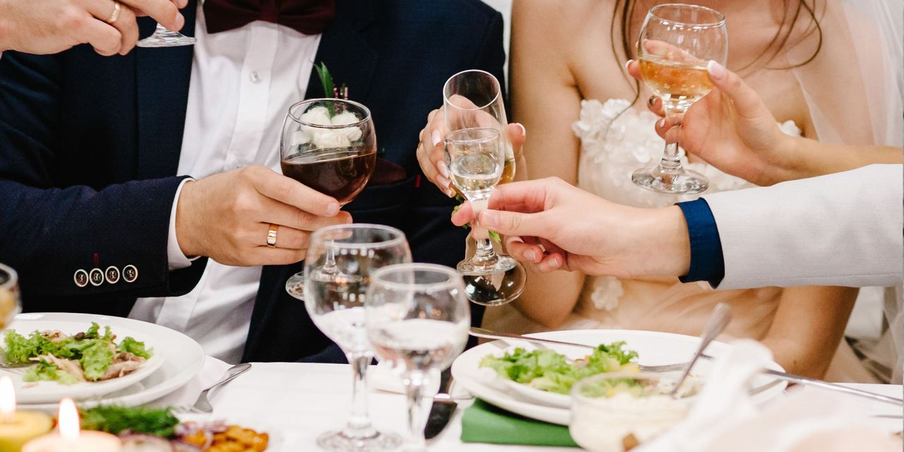 Bride and groom clinking glasses with guests at the reception | Source: Shutterstock