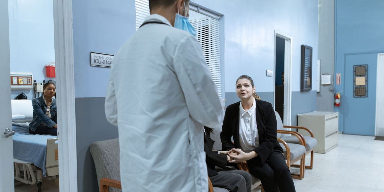 A concerned woman talking to a doctor at a hospital | Source: Pexels