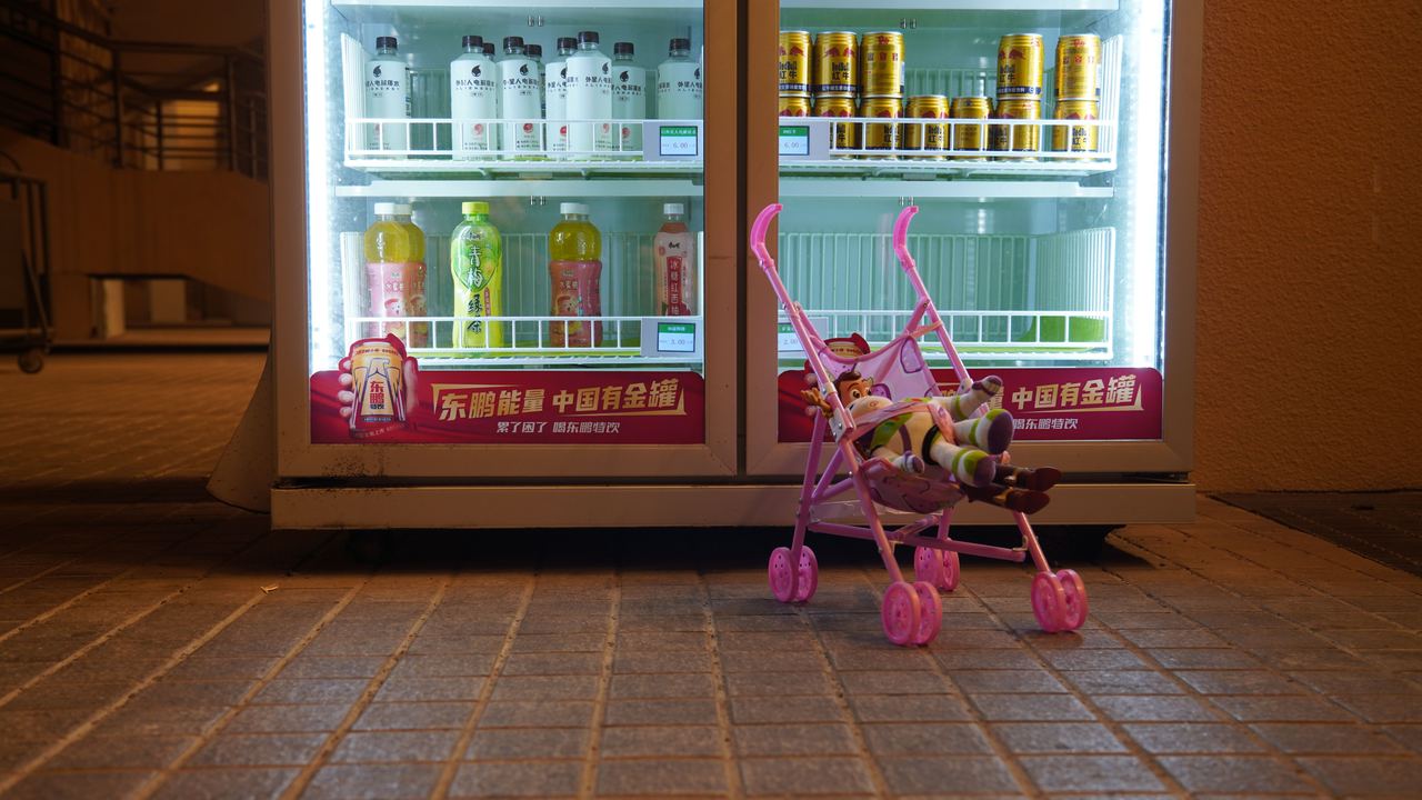 Baby toy stroller with doll in front of vending machine | Source: Pexels