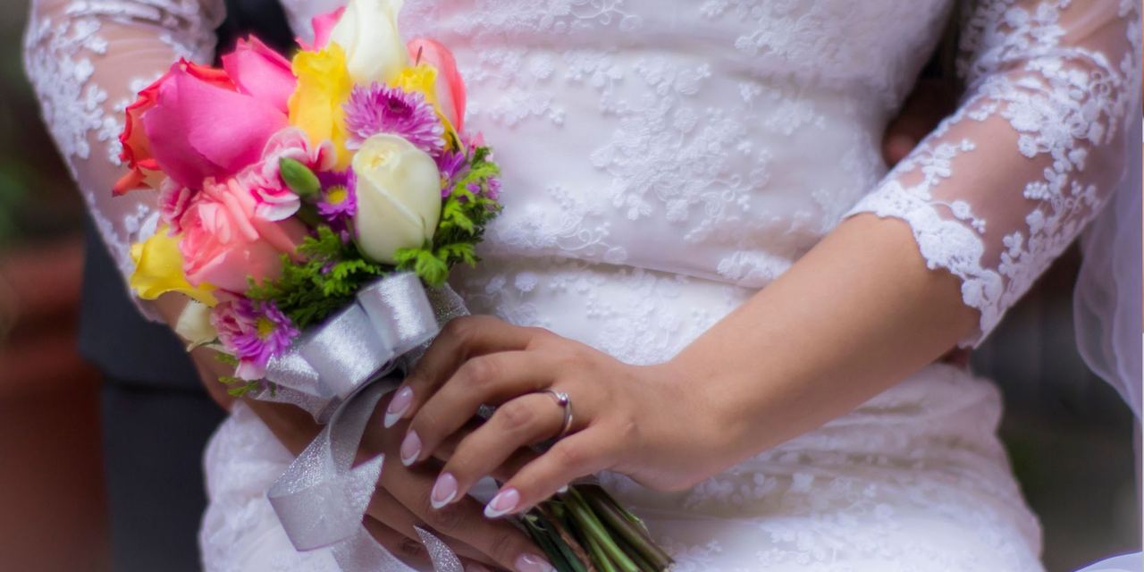 A bride holding a colorful wedding bouquet | Source: Pexels