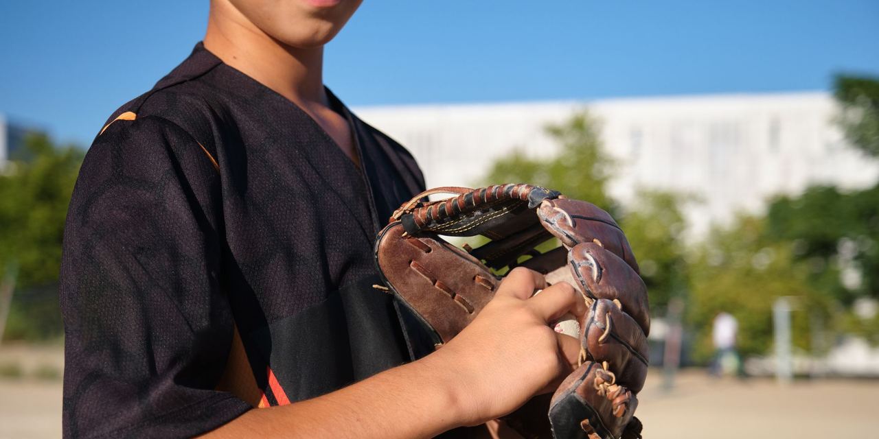 Young baseball player holding a glove | Source: Shutterstock