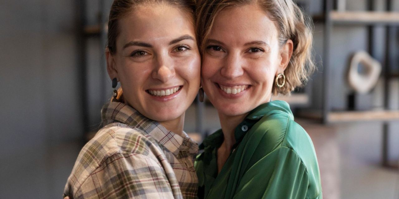 Two smiling women posing together | Source: Magnific