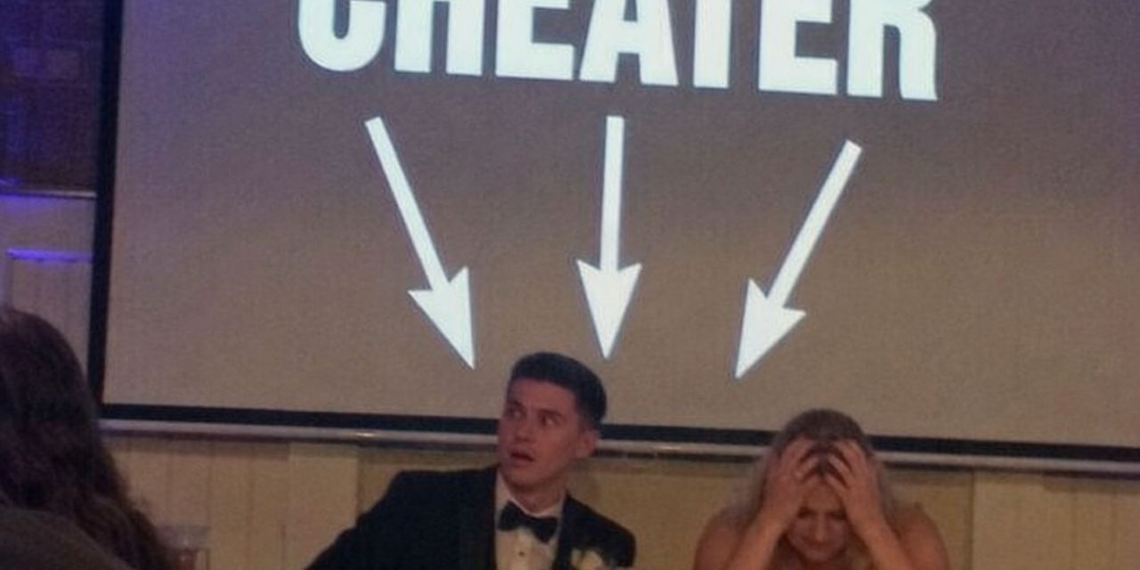 A groom looking shocked while sitting beside a distressed bride during a wedding reception, with a screen displaying "CHEATER" behind them | Source: Amomedia