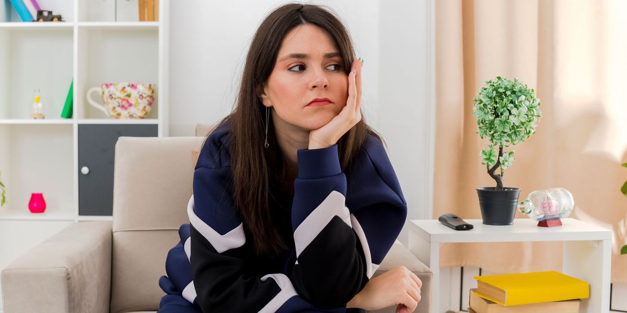 An unhappy woman sitting on an armchair | Source: Magnific