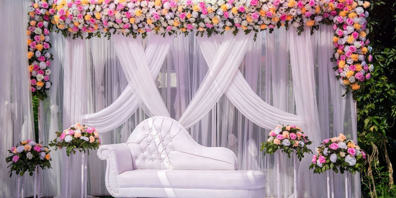 An elegant floral wedding stage decorated with draped fabric and pastel blooms | Source: Pexels