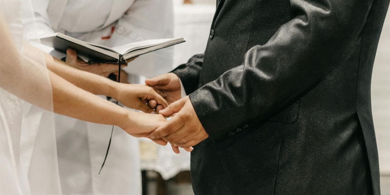 A bride and groom holding hands at the altar during their wedding ceremony | Source: Pexels