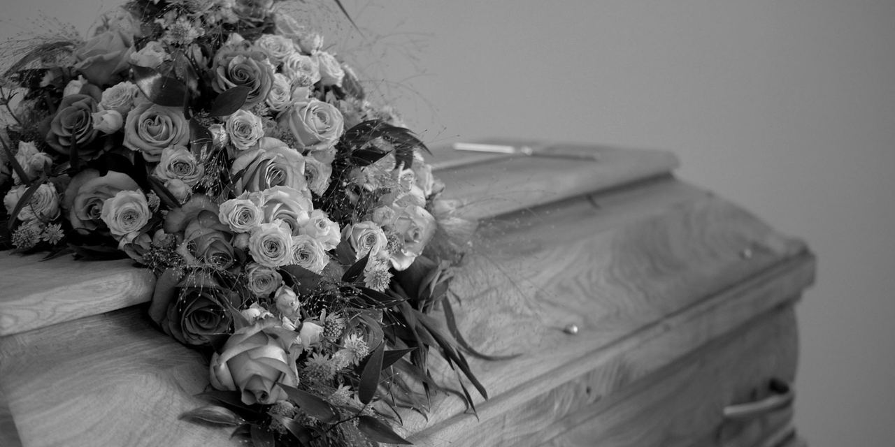 Bouquet resting on a coffin | Source: Pexels