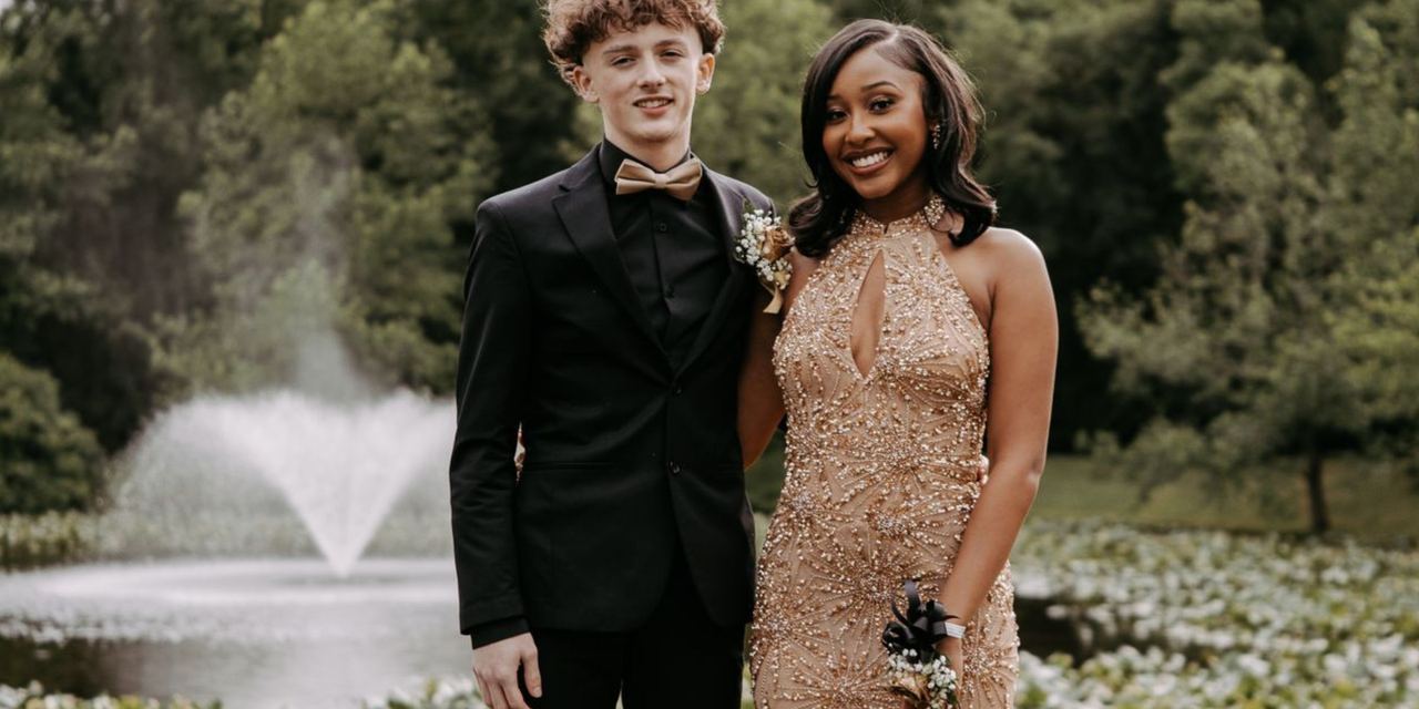 A young couple posing for a prom photo beside a lakeside fountain | Source: Pexels