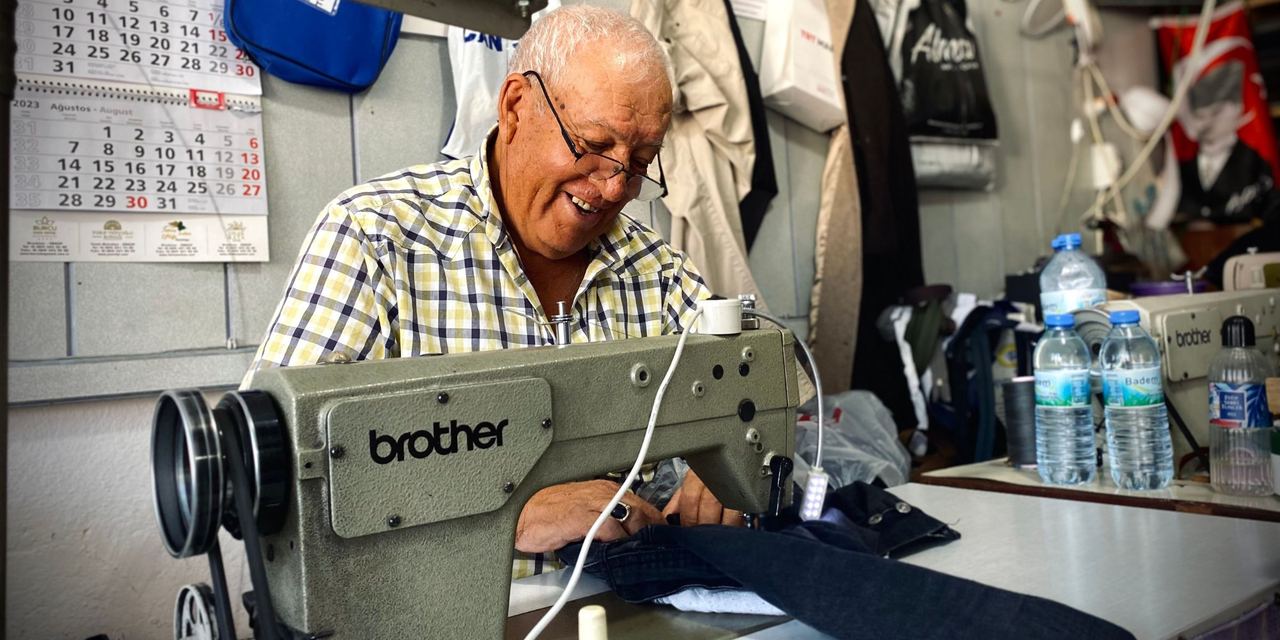 An elderly man using a sewing machine | Source: Pexels