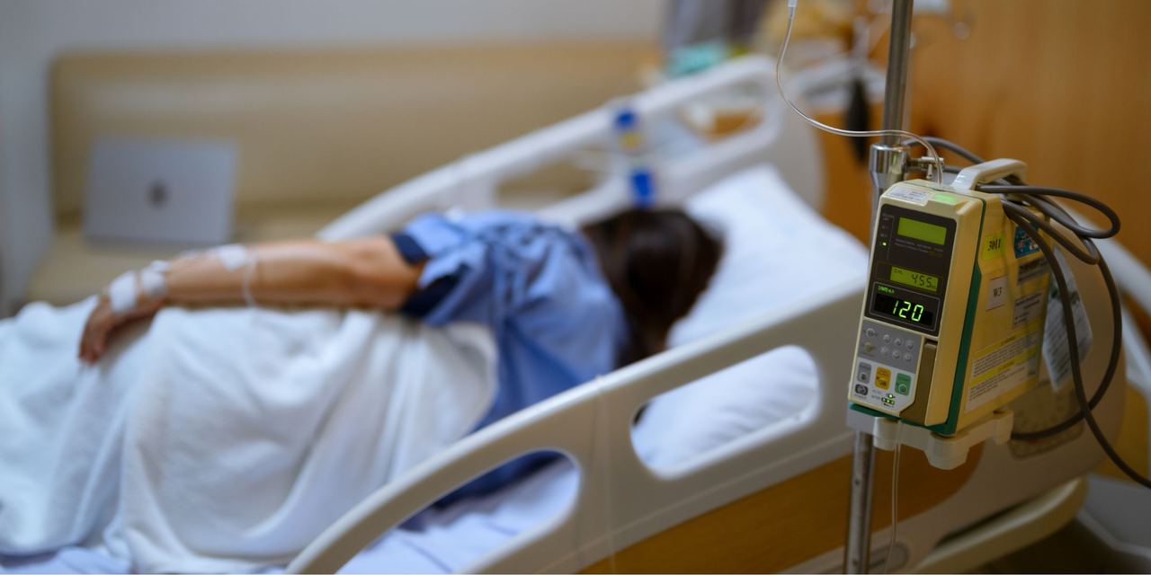 A woman lies in a hospital bed | Source: Shutterstock