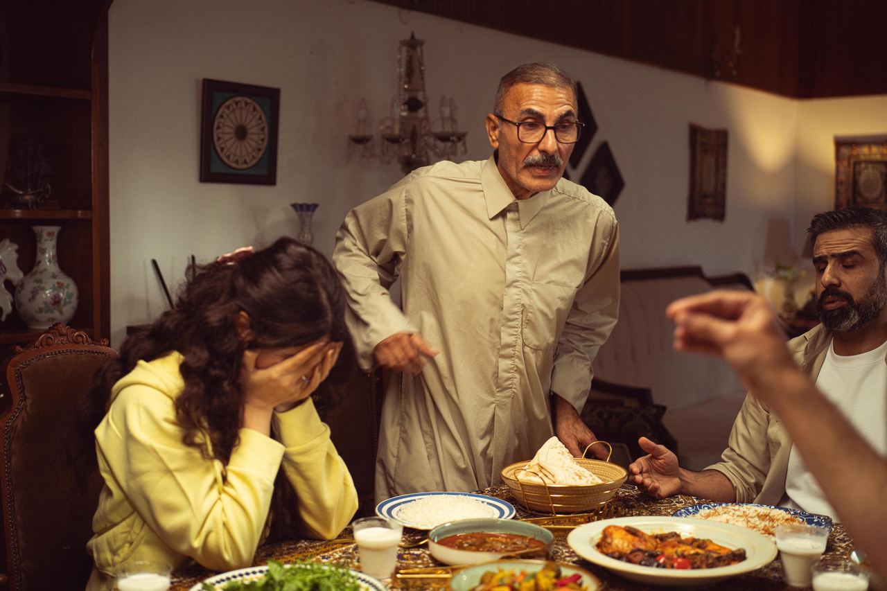 family gathered around the dinner table and engaged in a tense conversation | Source: Pexels