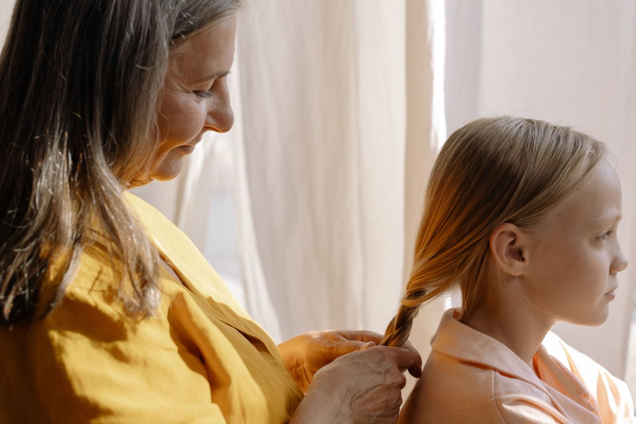 Woman braiding her grand-daughter's hair | Source: Pexels