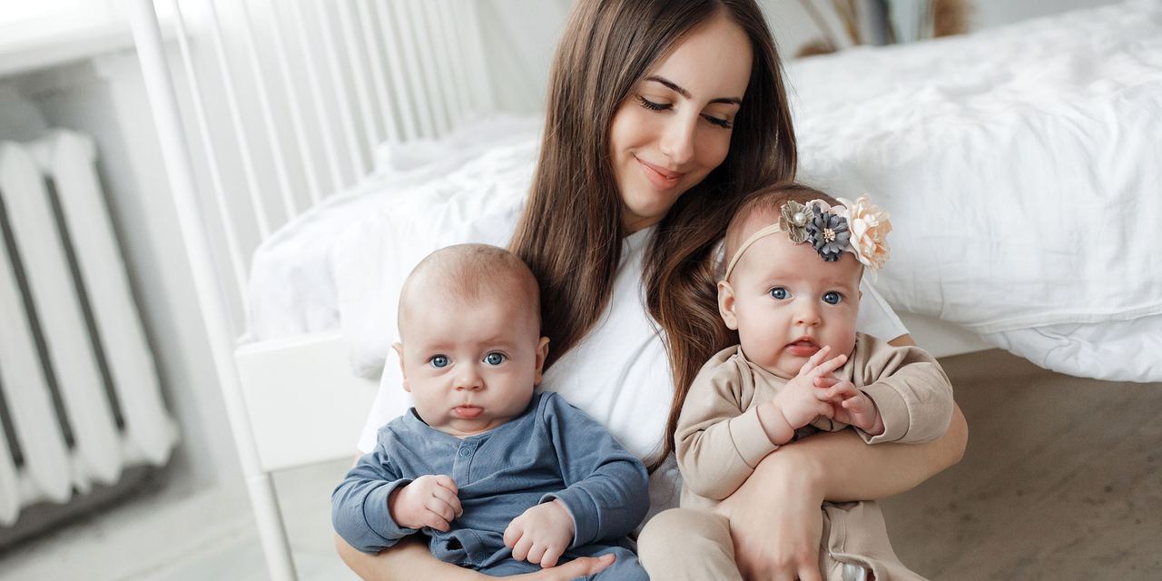 A mother holding her twins | Source: Magnific