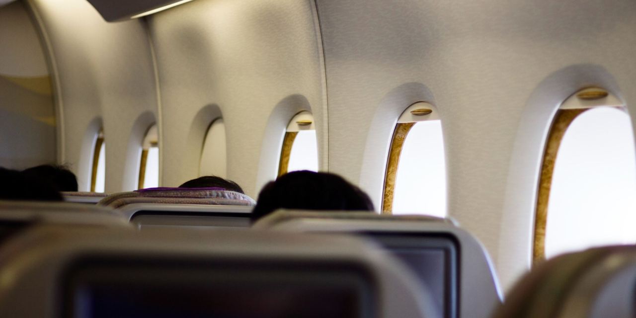 Passengers sitting inside an airplane cabin during a flight | Source: Magnific