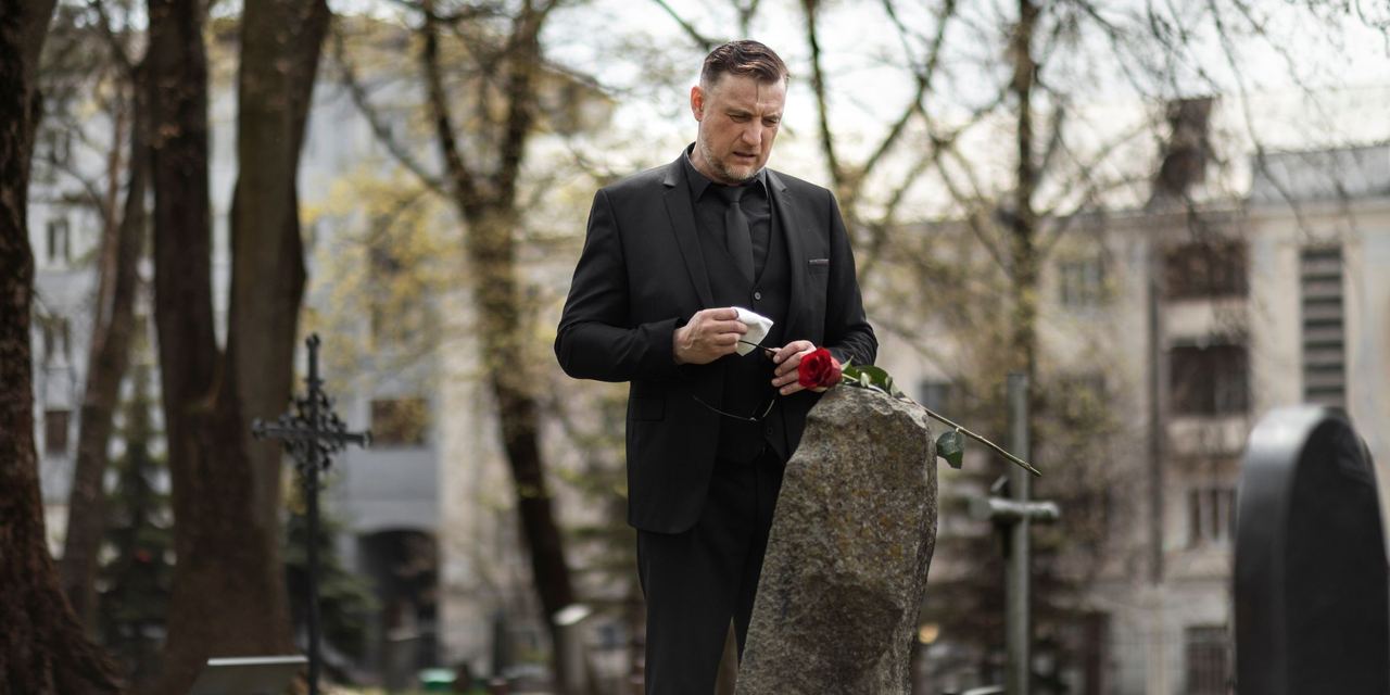 A sad man paying his last respect at the cemetery | Source: Magnific
