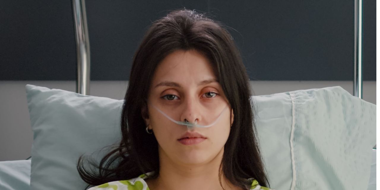 A sick woman with nasal oxygen tube resting in a hospital bed | Source: Magnific