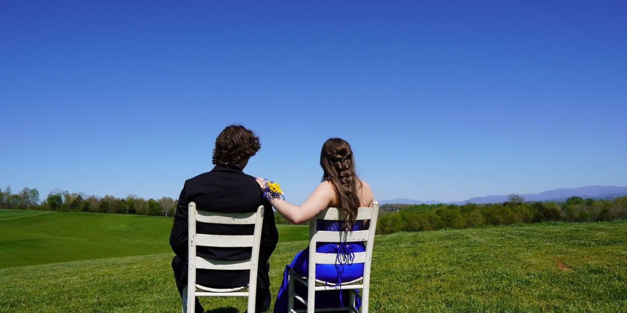 Young couple seated outdoors overlooking a field | Source: Pexels