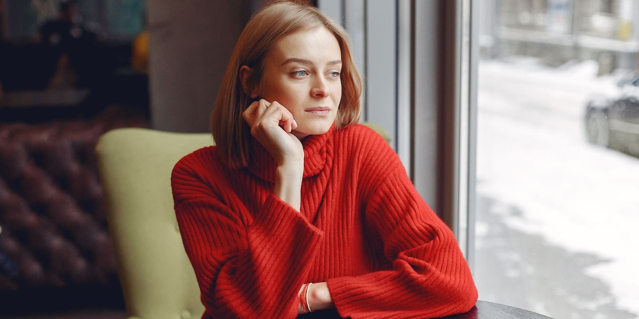 A woman sitting at a table | Source: Magnific