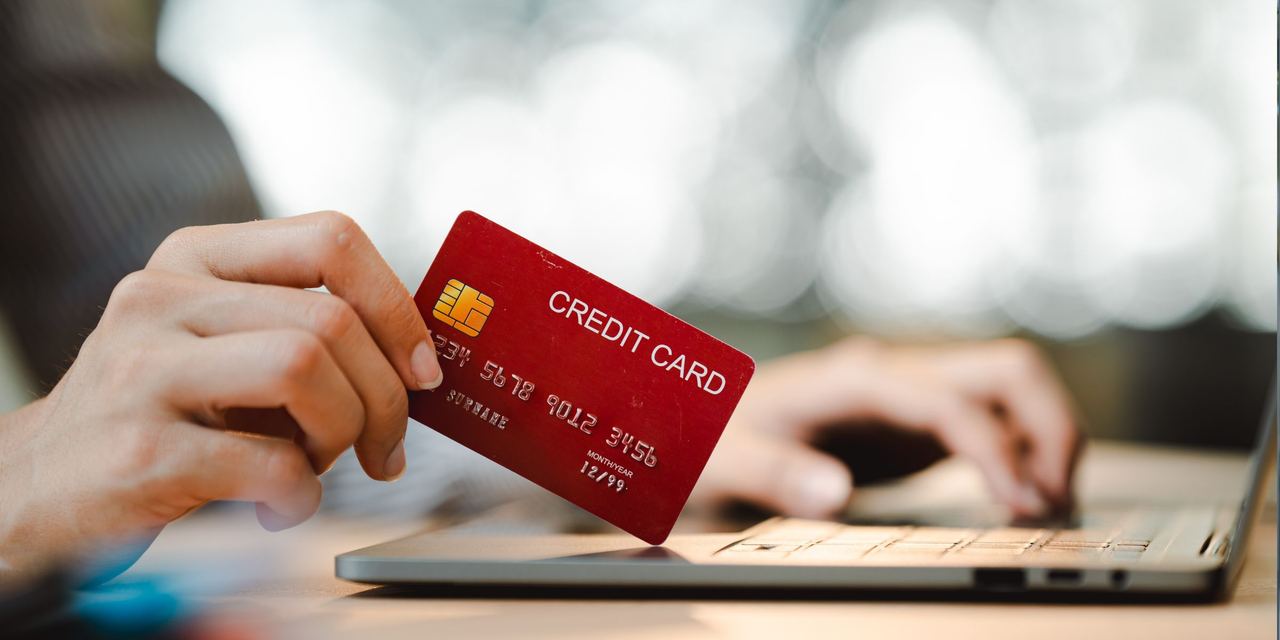 A woman entering credit card information on a laptop | Source: Shutterstock