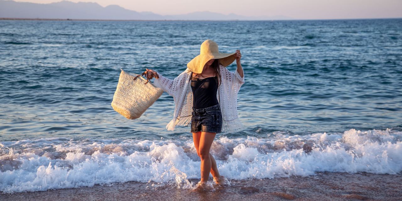 A happy woman enjoying the water at the beach | Source: Magnific