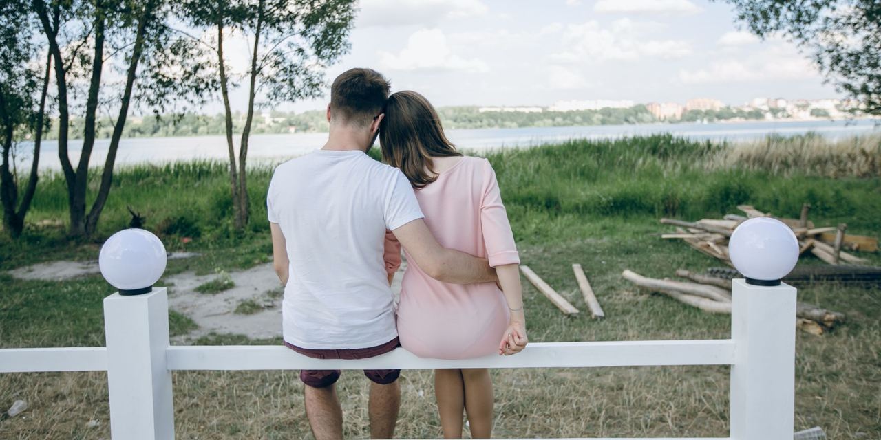 A couple sitting on a fence | Source: Magnific