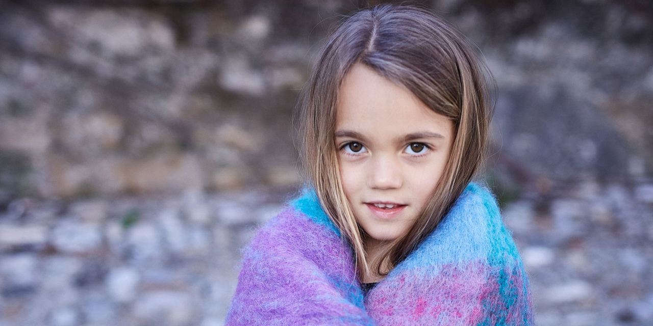 A little girl covered in a blanket | Source: Magnific