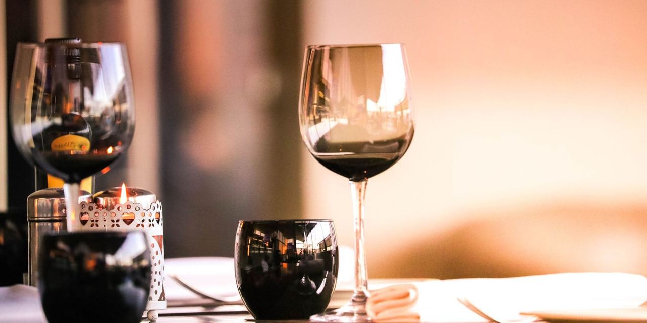 Wine glasses and candlelight on a restaurant dining table | Source: Pexels