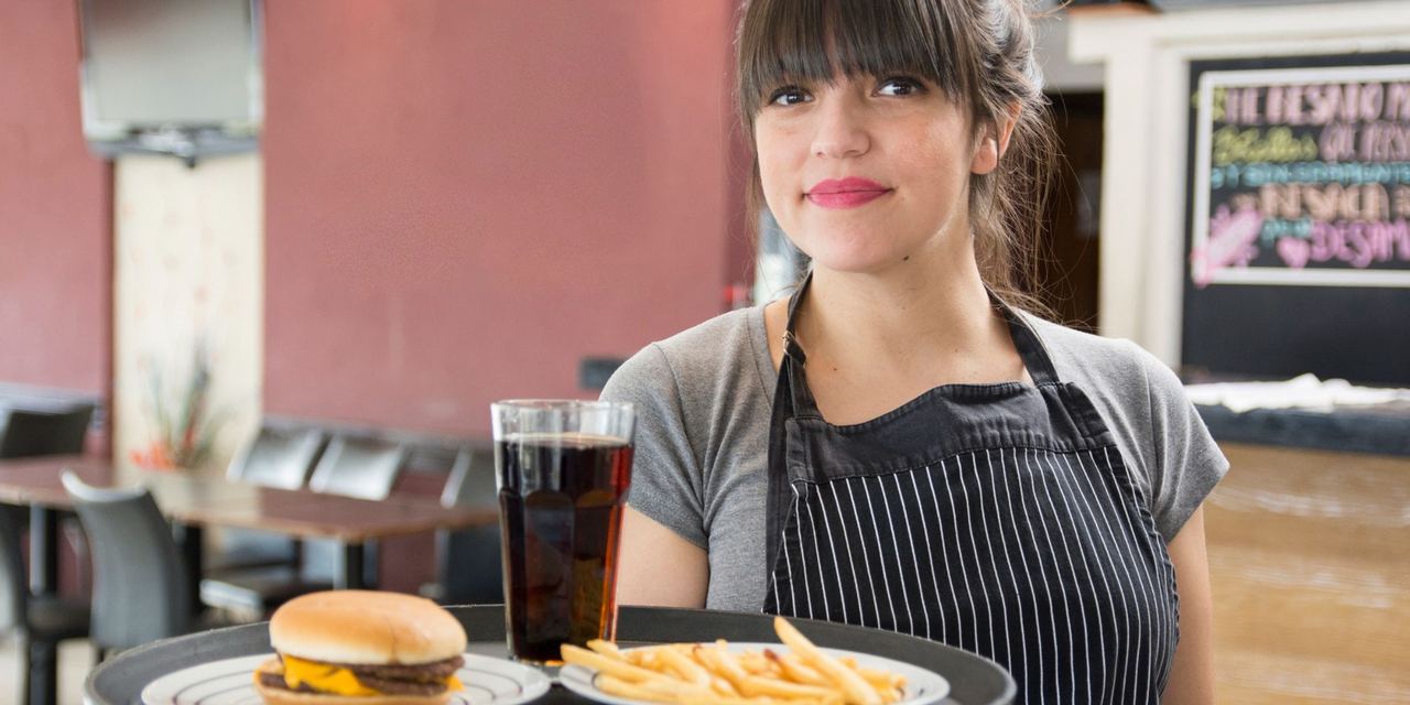 A waitress holding a tray | Source: Magnific