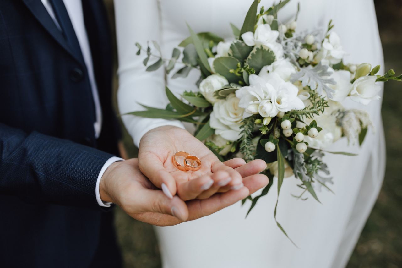 A couple holding their wedding bands | Source: Magnific