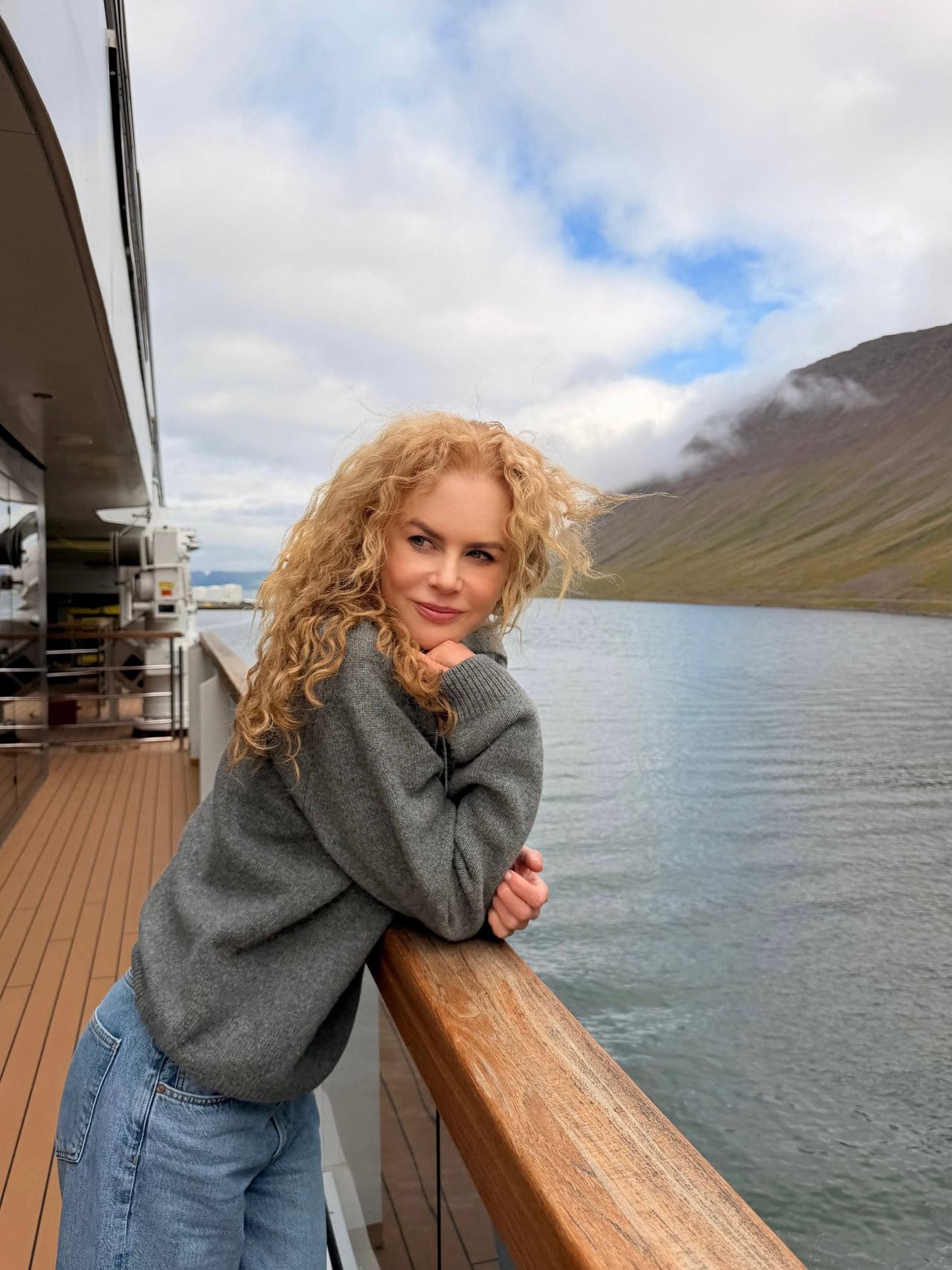 Nicole Kidman shows off her signature natural curls while leaning against the railing of a luxury Ritz-Carlton yacht off the coast of Iceland. Wearing a cozy gray sweater and denim jeans, the star embraced the windswept look during her family getaway. | Source: Instagram/nicolekidman