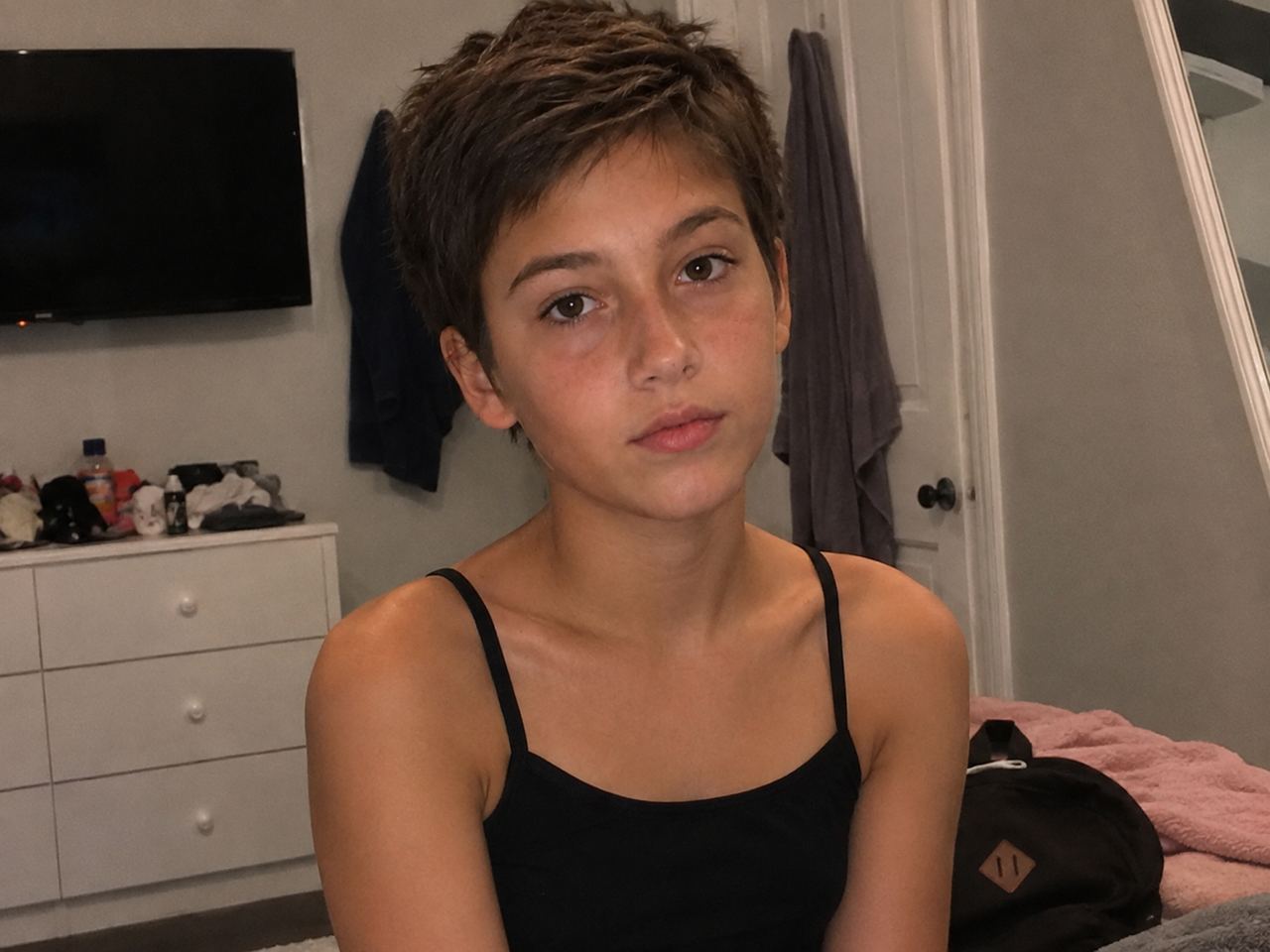 A girl with a short dark haircut wearing a black top | Source: TheCelebritist