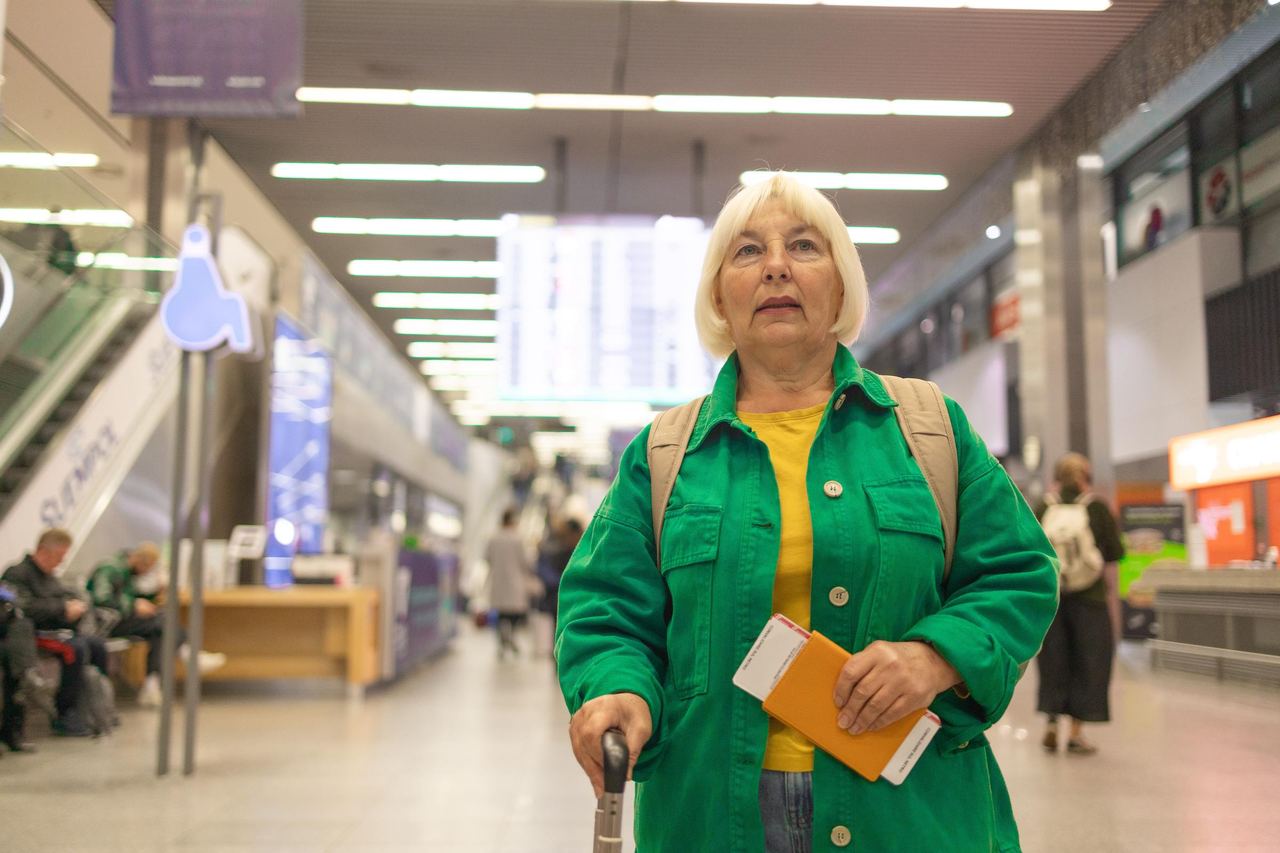 An elderly lady wiating to board her flight | Source: Shutterstock