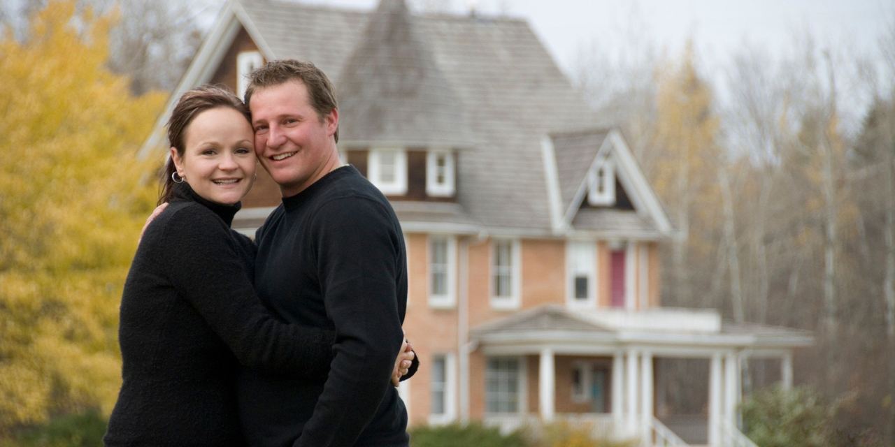 A smiling couple embracing outside their home | Source: Getty Images