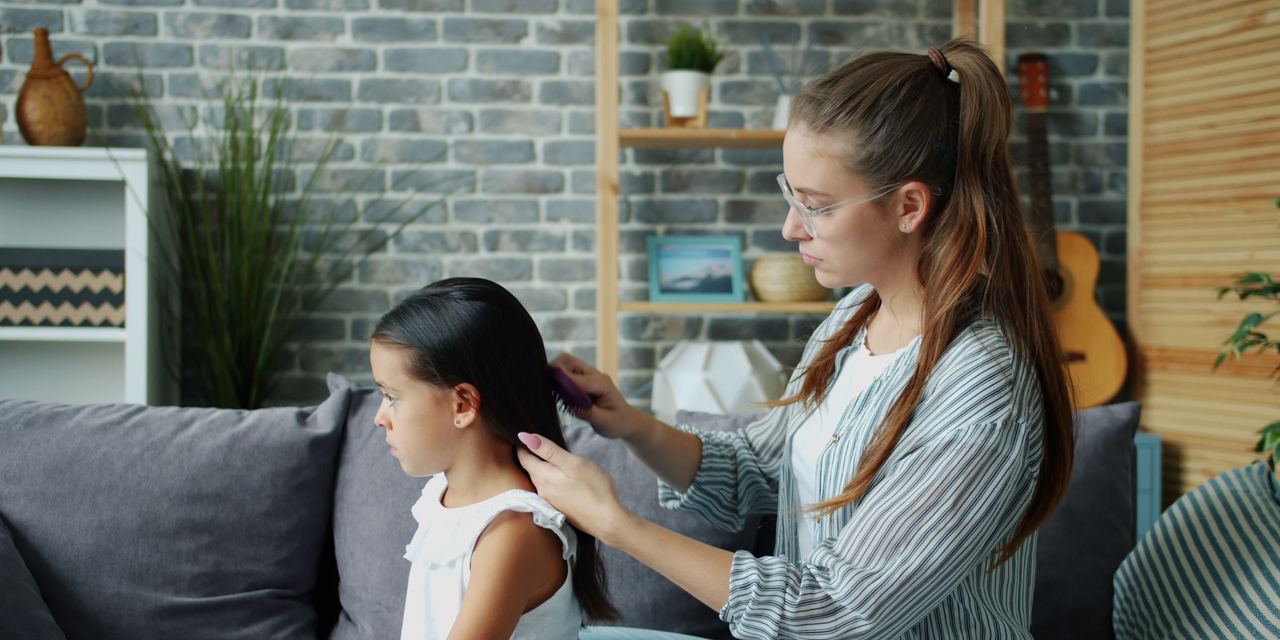 A mother brushing her daughter's hair | Source: Pexels