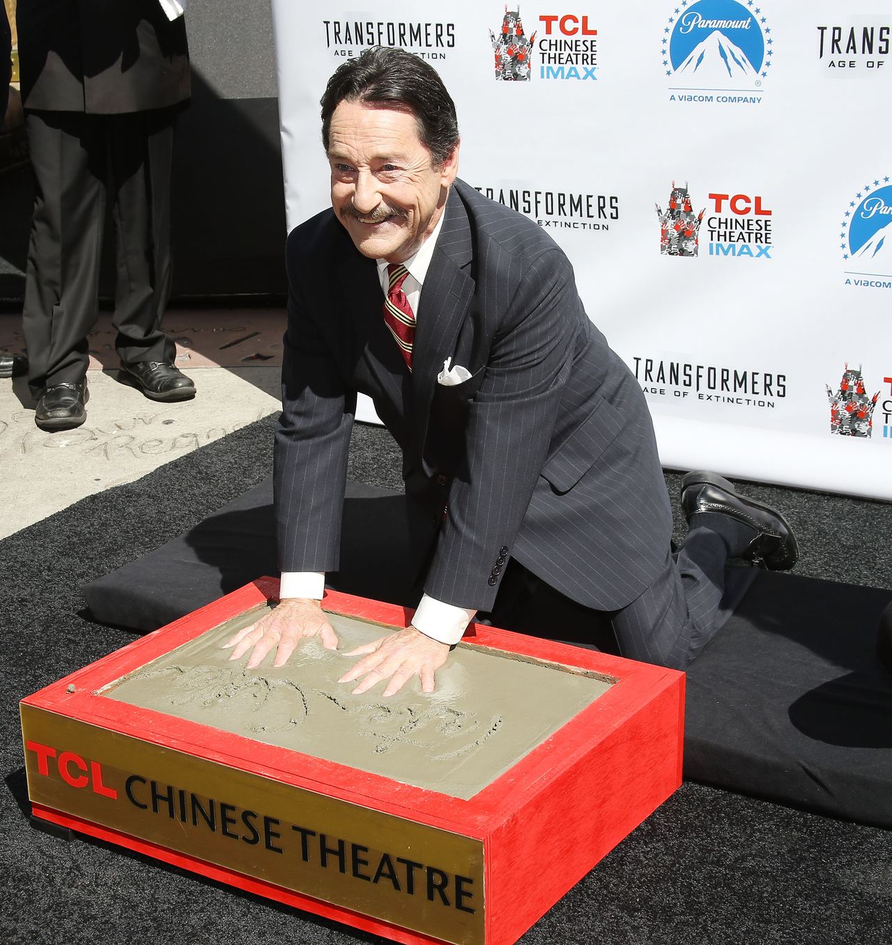 Peter Cullen leaves his handprints and footprints in cement at the TCL Chinese Theatre in Hollywood in 2014, marking a rare honor that recognized the man behind Optimus Prime rather than the character alone. The ceremony came as Cullen’s voice had become inseparable from the heroic Autobot leader. | Source: Getty Images